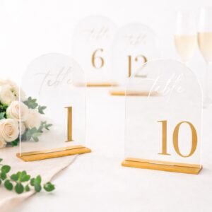 Clear acrylic arch signs with gold numbers and stands for wedding reception tables